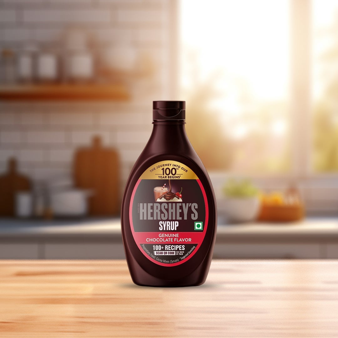 Boy pouring HERSHEY'S SYRUP in a glass of milk